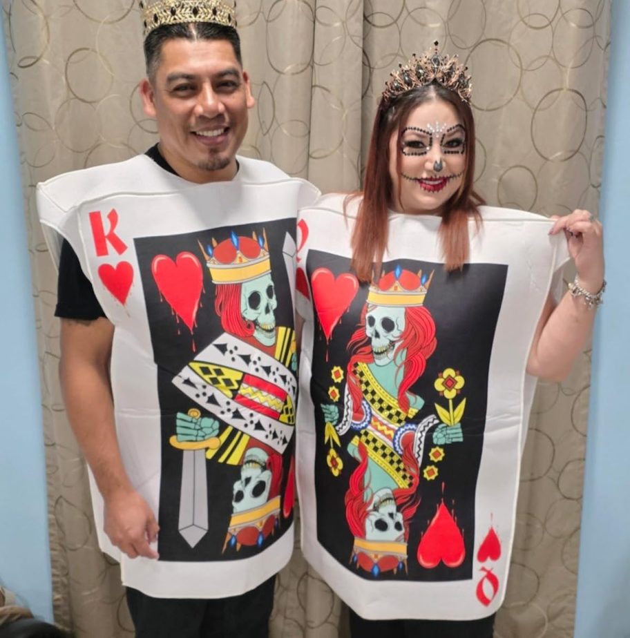 man and woman posing in king and queen of hearts costumes