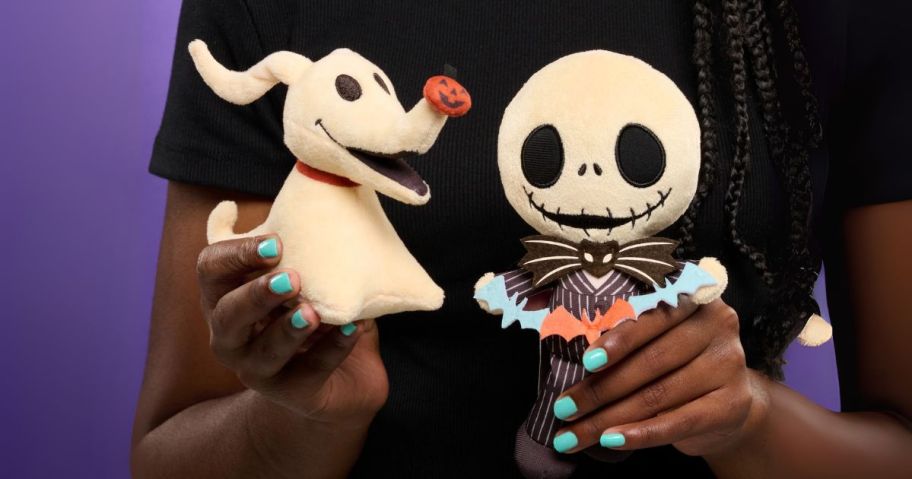 kid holding nightmare before christmas zero and jack skellington plushies
