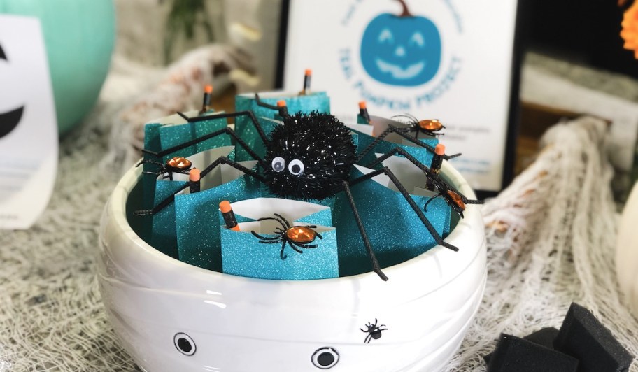 white halloween bowl with teal goodie bags inside