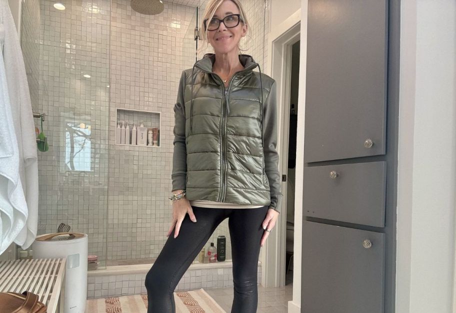 a woman taking a selfie in a green quilted jacket