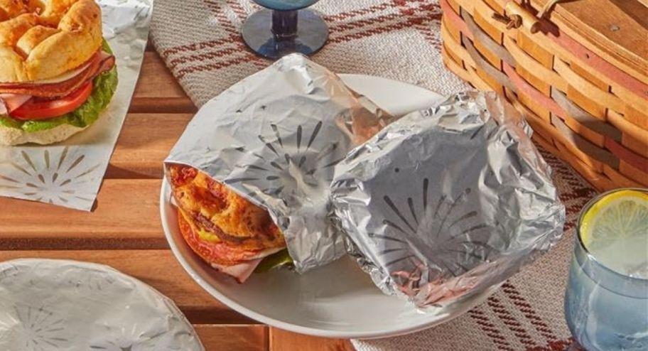 Burgers and other dishes wrapped in fireworks tin foil on a plate