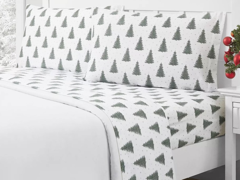 christmas tree print sheet set on a bed