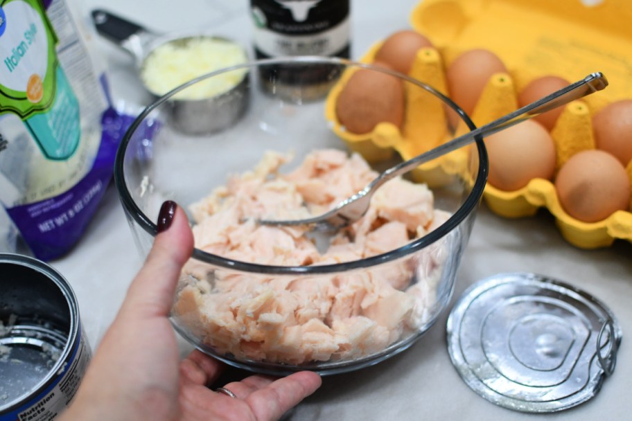 adding canned chicken to a mixing bowl