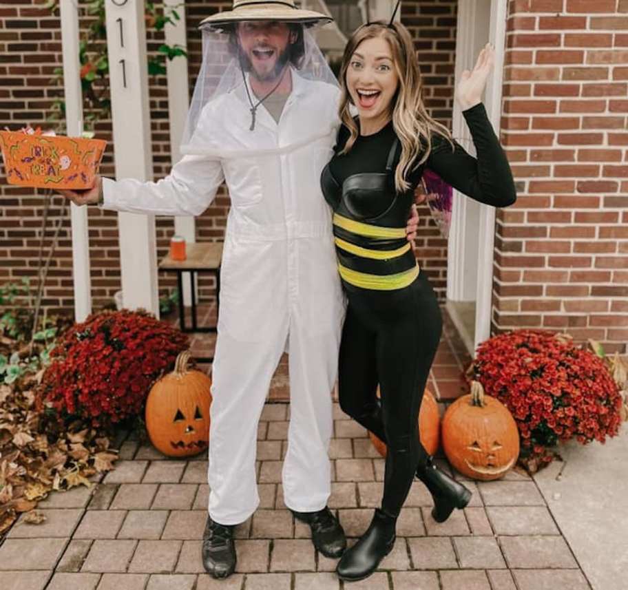 couple wearing beekeepers and bee costumes on halloween porch