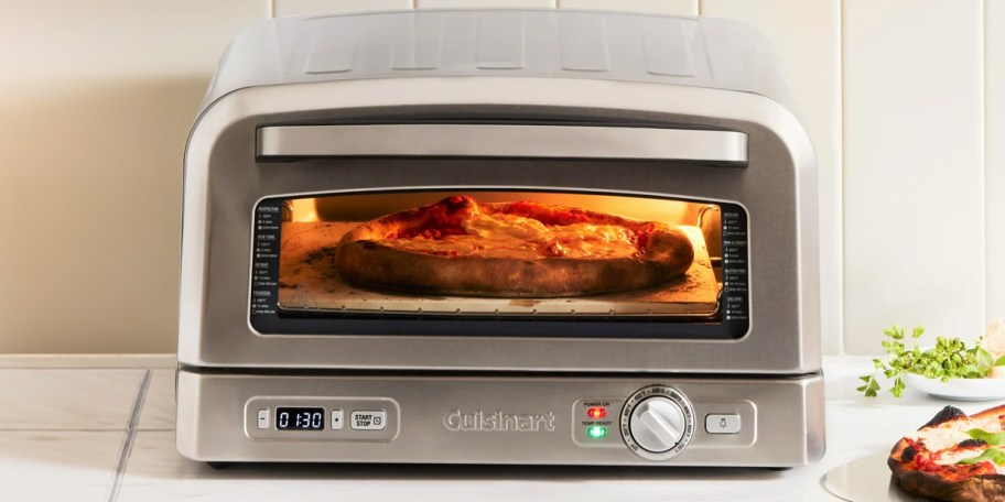 stainless steel cuisinart pizza oven with pizza cooking inside 