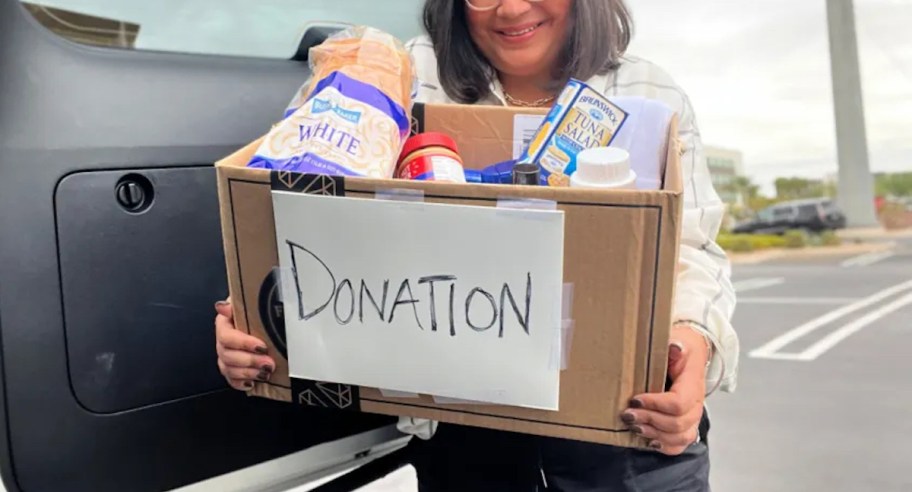 woman holding donation box full of food items