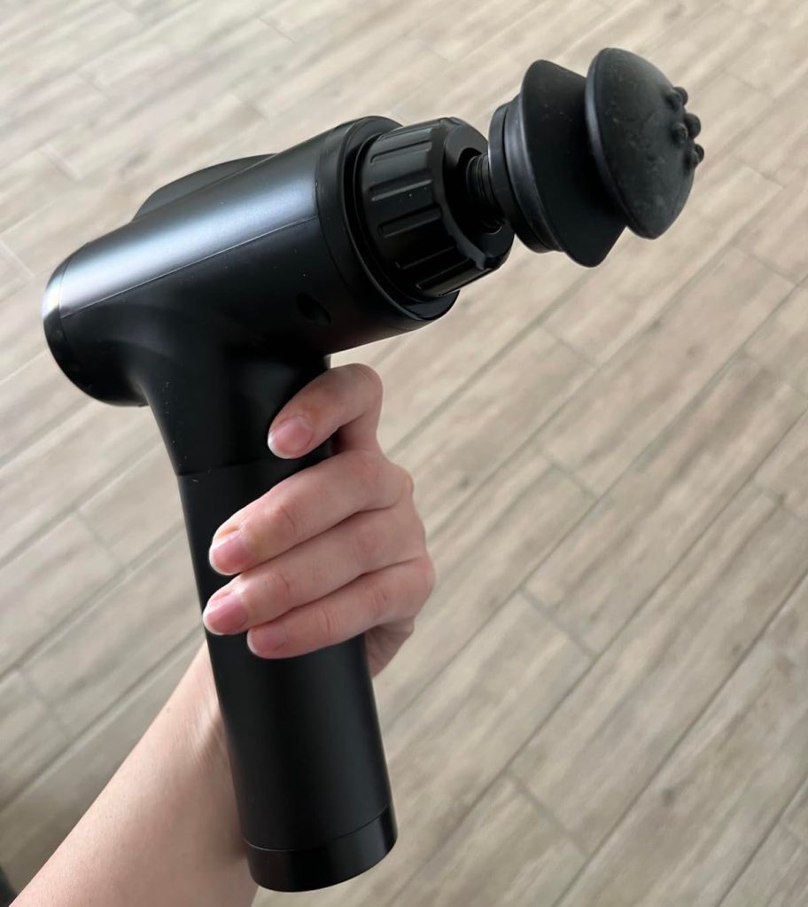 hand holding black massage gun
