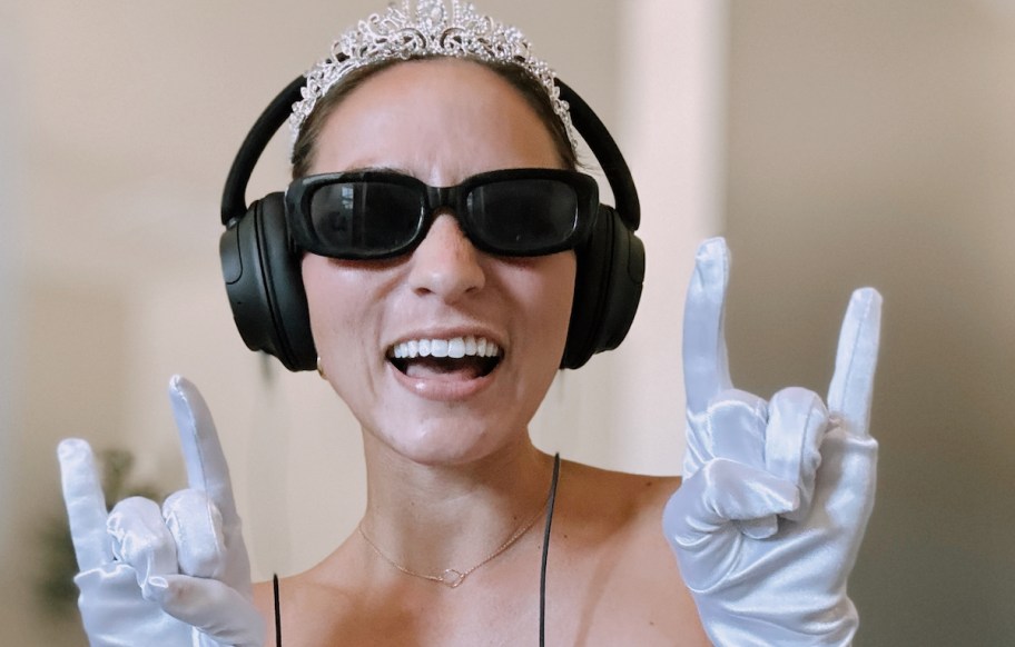 women wearing black sunglasses and headphones holding up rocker signs with hands