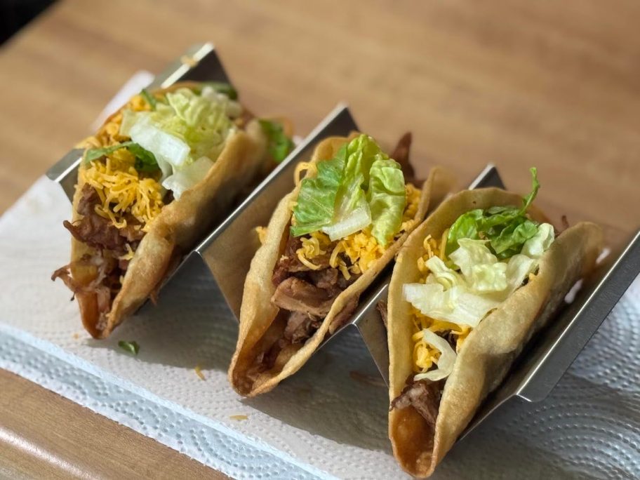 Stainless steel taco holder with three taco sitting inside 