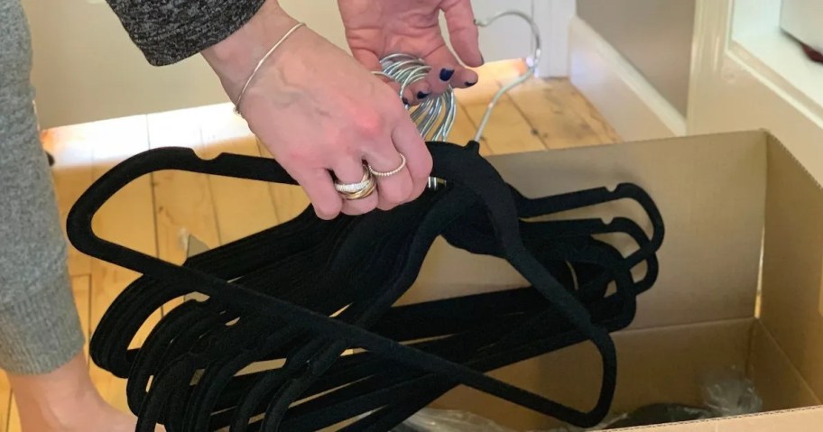 hand holding pile of velvet hangers