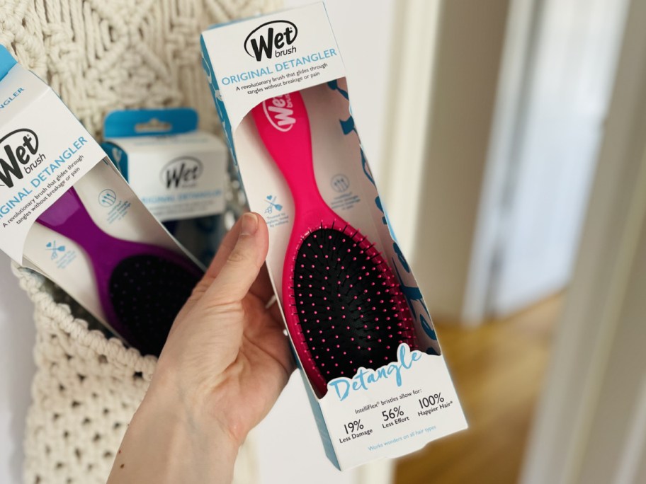 hand holding pink wet brush in box