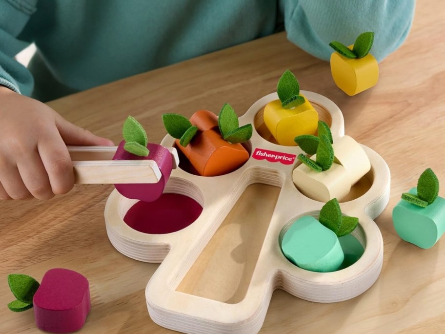 kid playing with a wood tree and fruit counting toy
