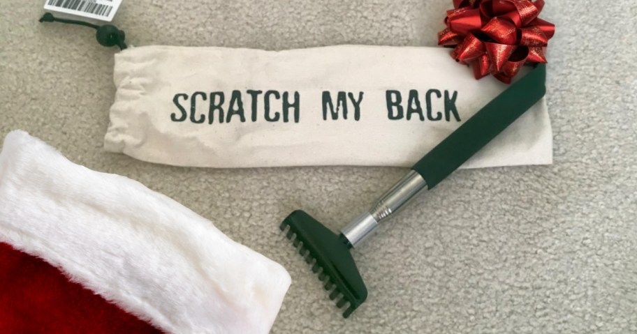 back scratcher on carpet floor with red bow and stocking