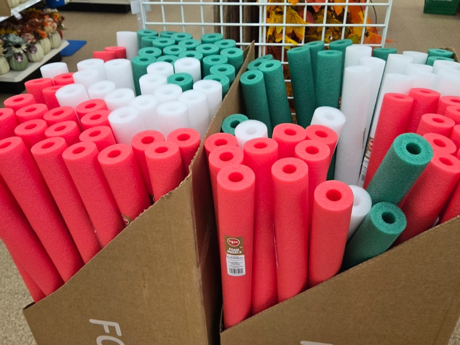 green, white and red pool noodles in boxes 