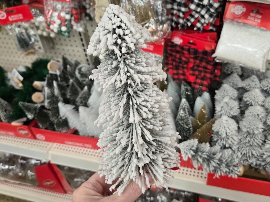 hand holding white flocked mini Christmas tree