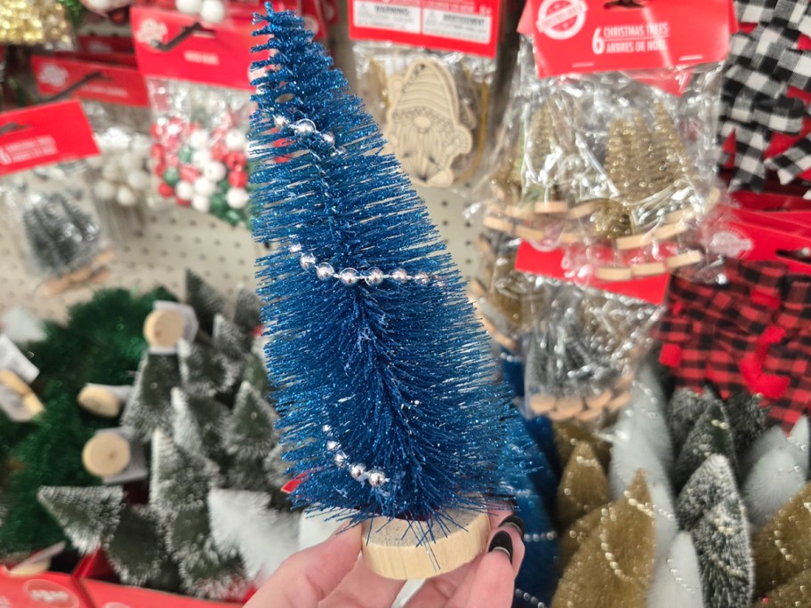 hand holding blue mini christmas tree 
