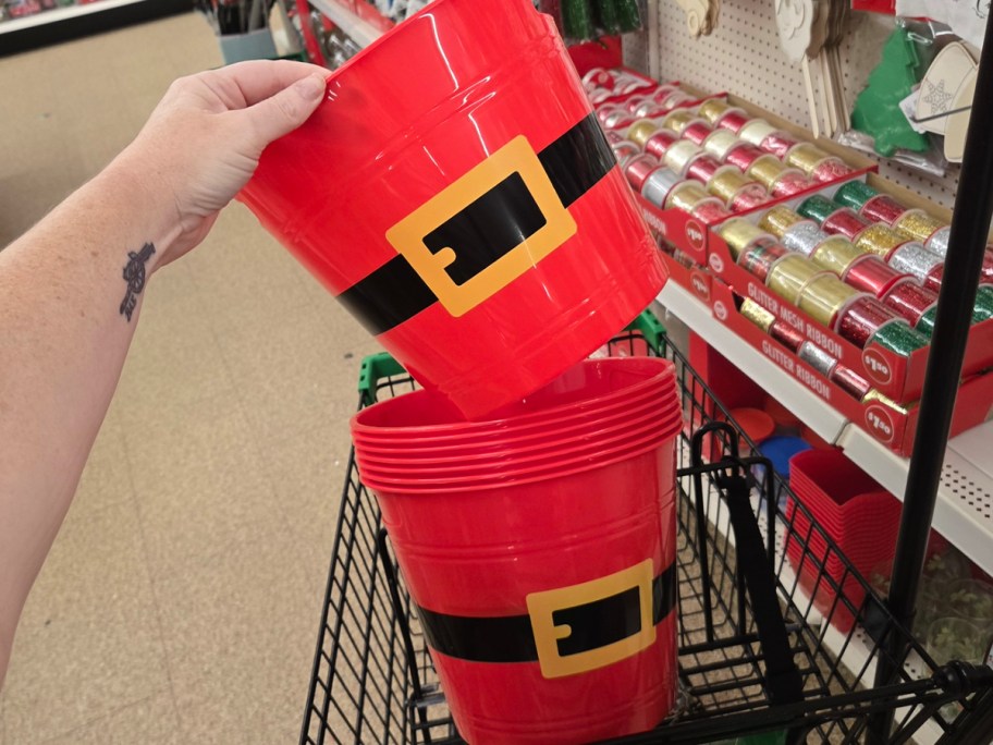 hand reaching for stack of santa buckets 