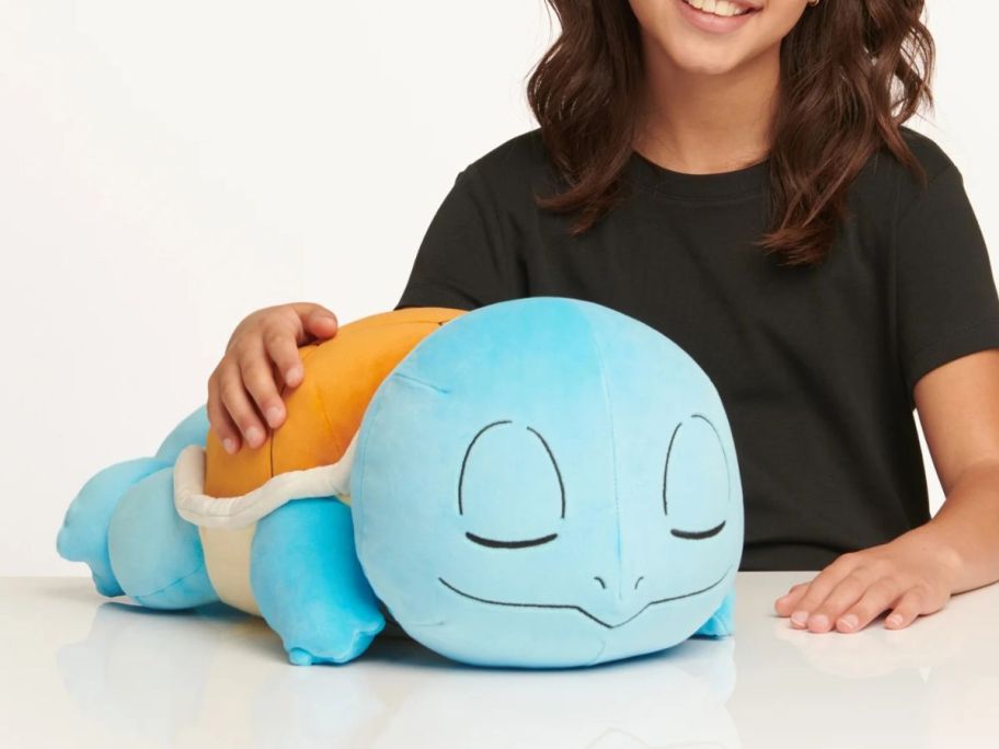 kid holding Pokemon Sleeping Plush