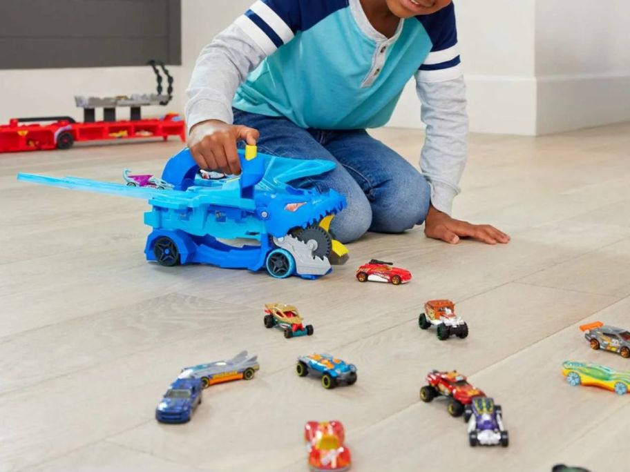 kid playing with Hot Wheels City Ultimate Dual Dragon Transporter on floor