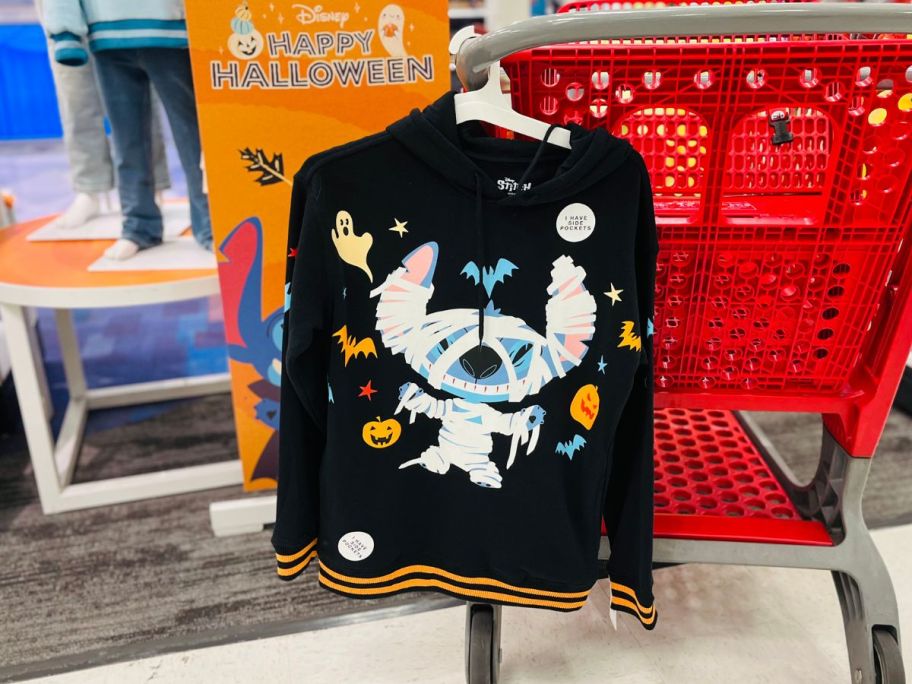 a black sweatshirt with a Stitch mummy hanging on a Target cart