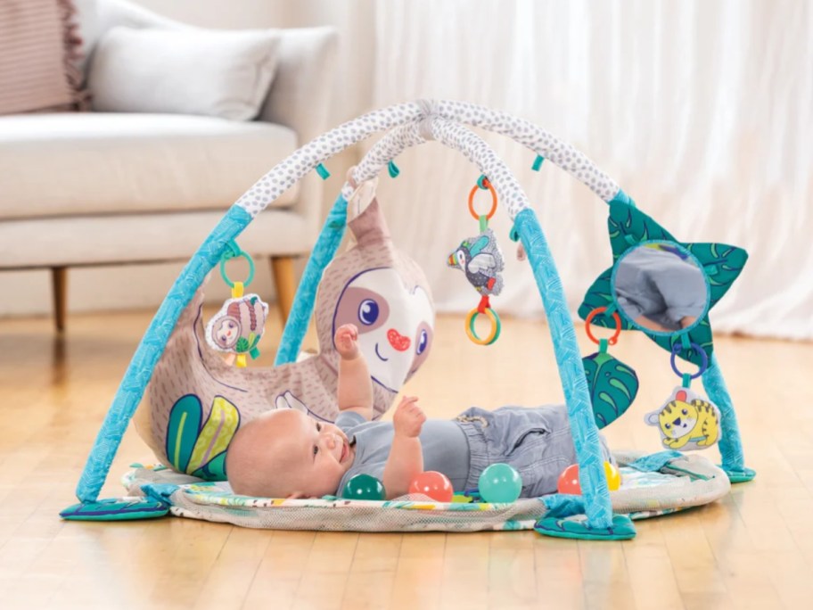 a baby laying on an activity gym playmat
