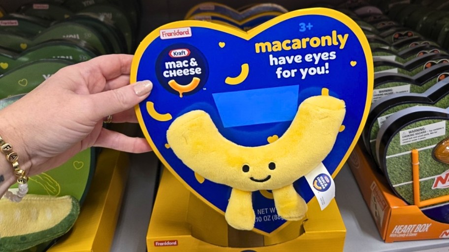 a womans hand holding a Valentines Heart Box with plush and gummy candy 