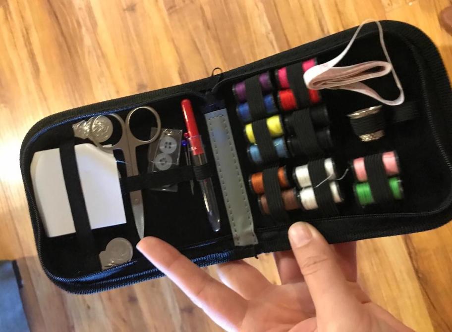 hand holding travel sewing kit