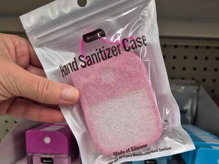 hand holding a hand sanitizer case in the packaging in a store