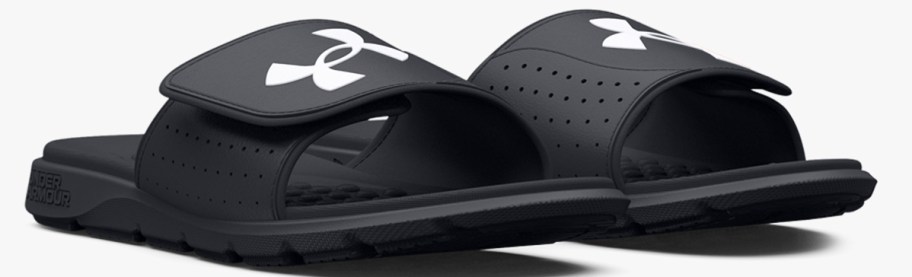 pair of black slides with white under armour logo