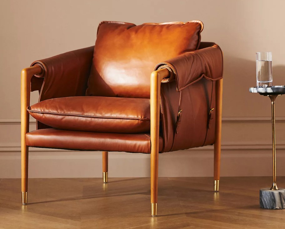 leather chair with buckles on herringbone wood floor