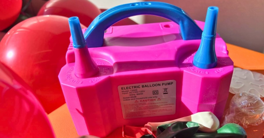 pink balloon pump on a table with balloons