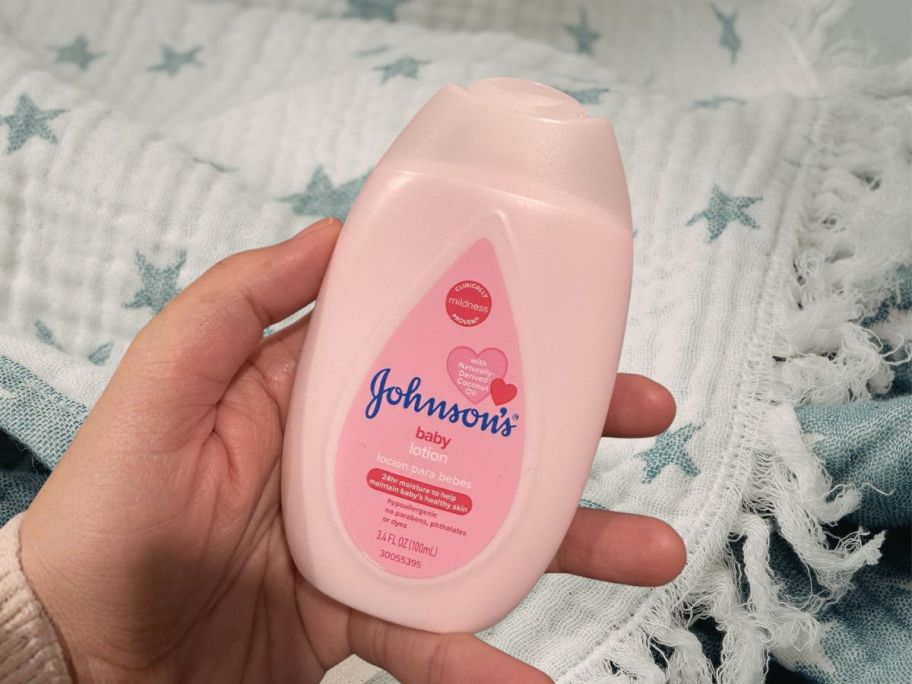 hand holding johnsons baby lotion bottle