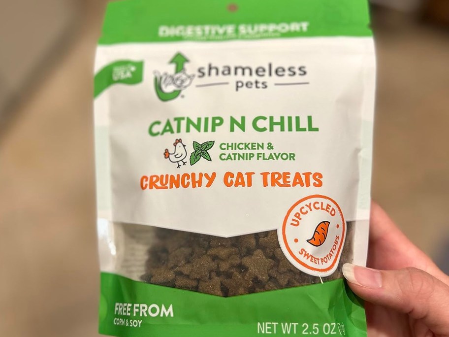 holding a bag of cat treats