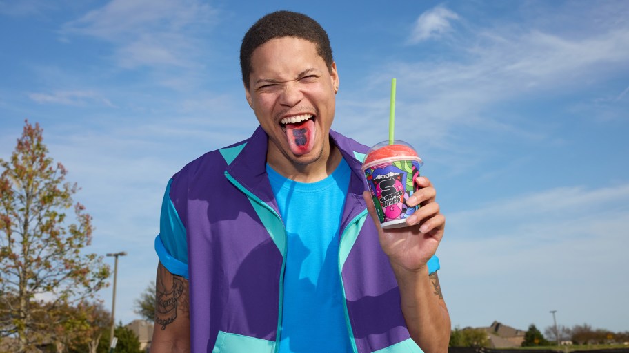 man with tongue out holding Slurpee
