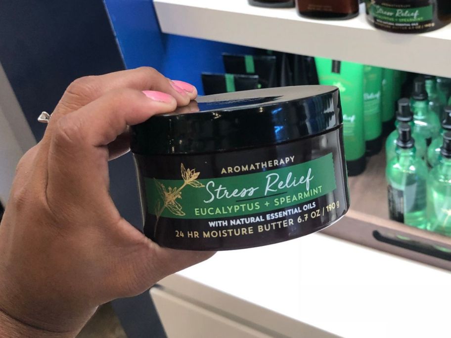 Hand holding a Bath & Body Works Stress Releif Aromatherapy Body Butter 