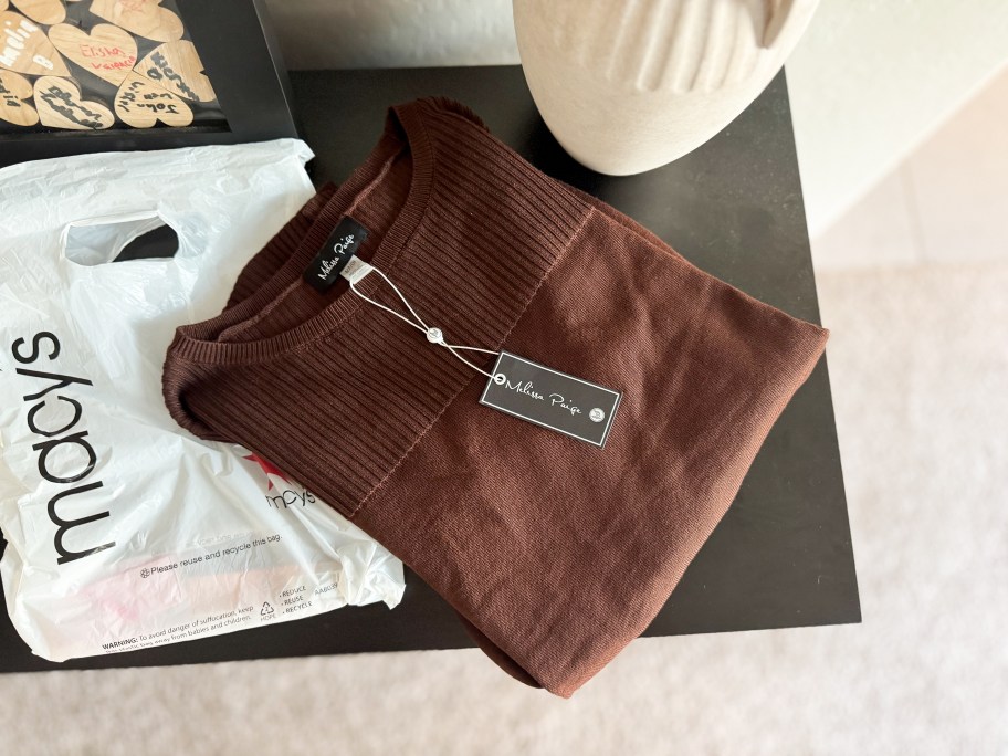 A brown sweater and a Macy's bag.