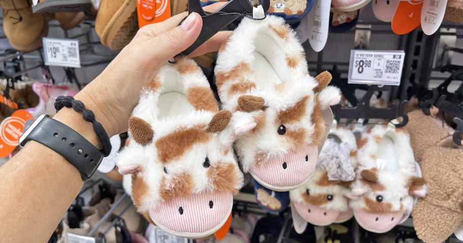 hand holding up a pair of farm animal baby slippers