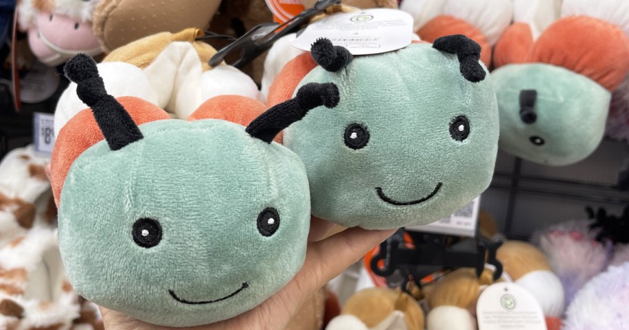 hand holding up a pair of bug slippers