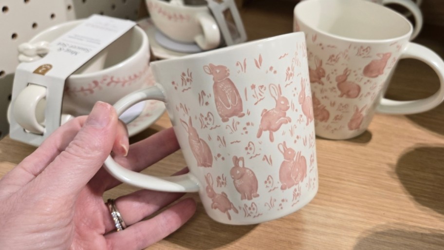 womans hand holding a hand painted rabbit mug