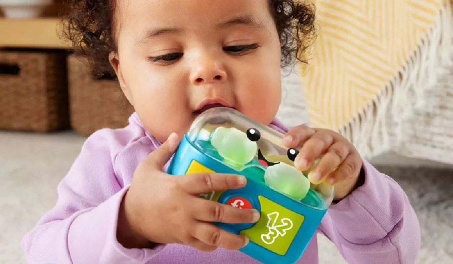 baby holding fisher price ear buds