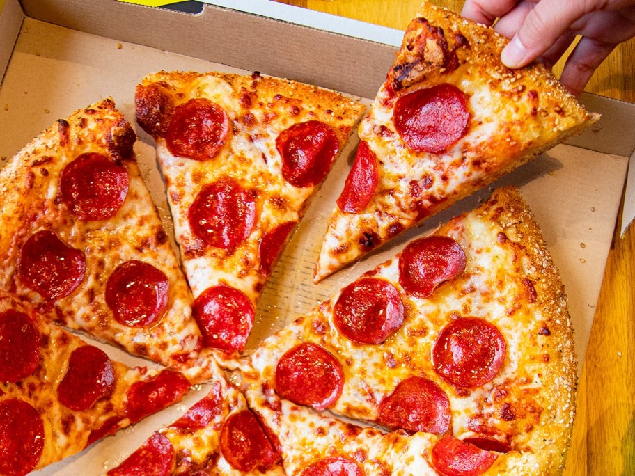 lifting a slice of pizza from a box
