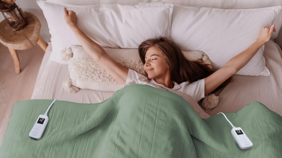 a woman in bed under an electric blanket