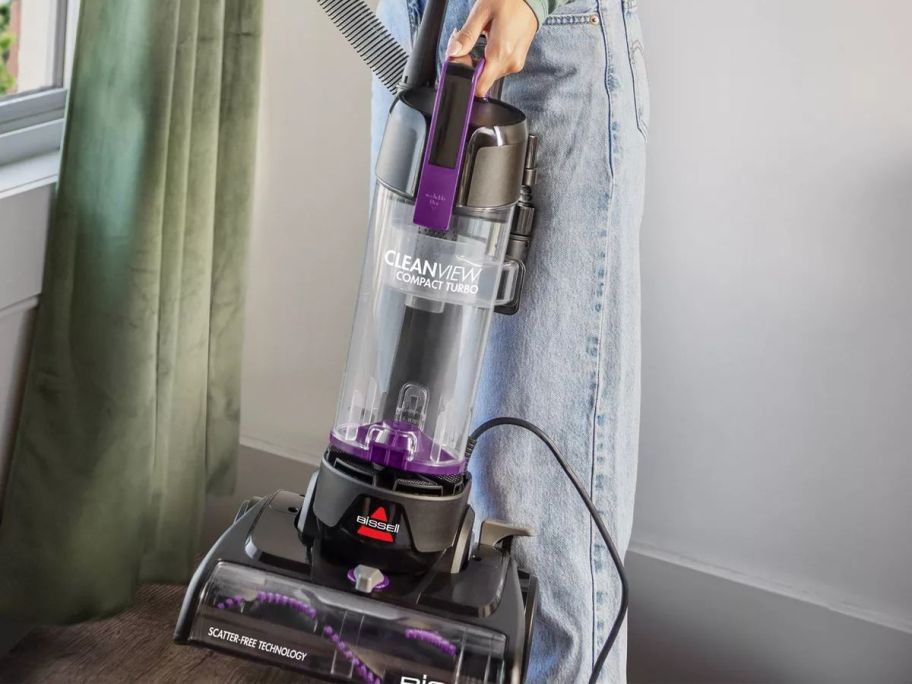 Person holding a Bissell CleanView Compact Turbo Upright Corded Vacuum