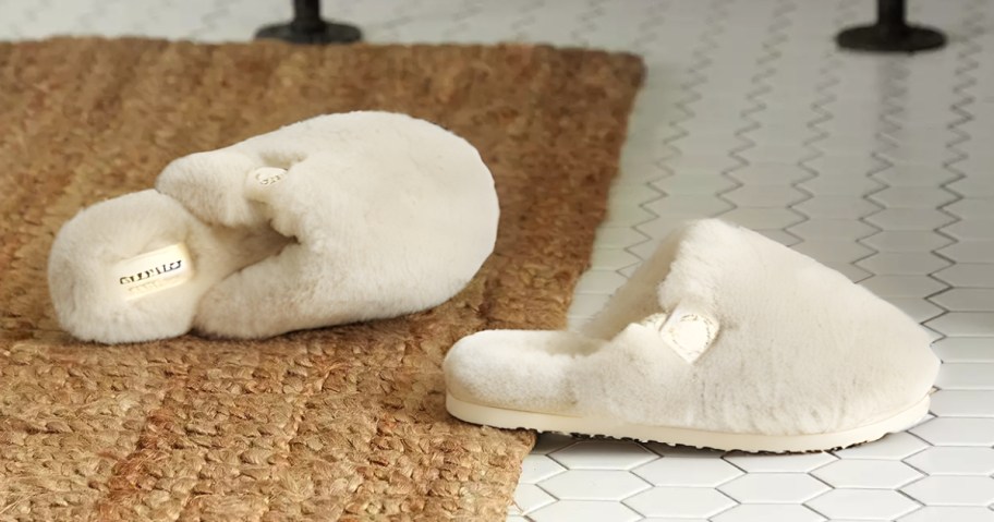 a pair of cream fuzzy slipper on a bathroom floor