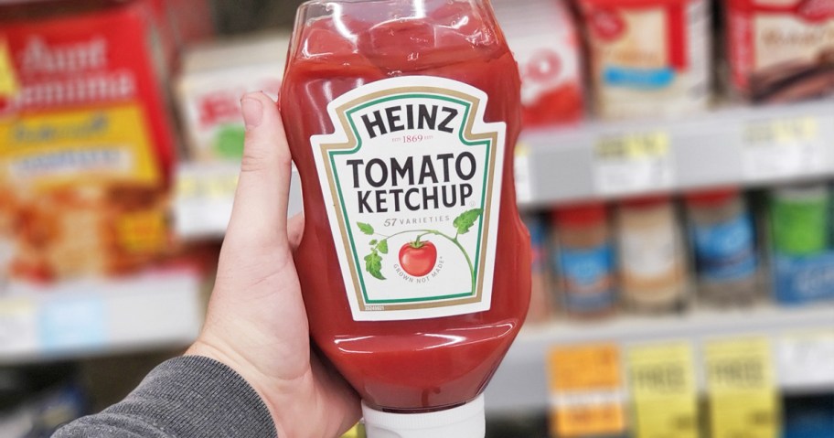 hand holding up a bottle of Heinz Tomato Ketchup in store