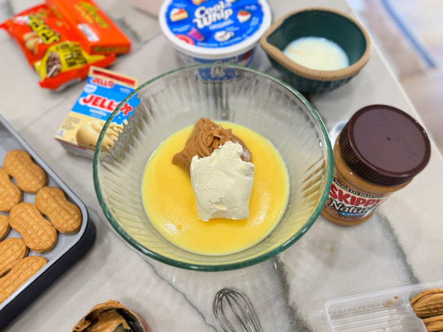 adding vanilla pudding, cream cheese, and peanut butter to a pan
