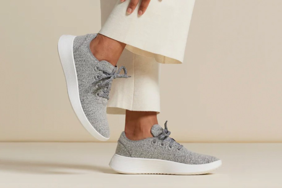 woman wearing grey sneakers and white pants