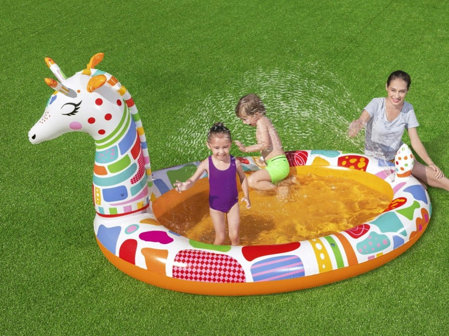 kids playing in rainbow giraffe splashpad pool 
