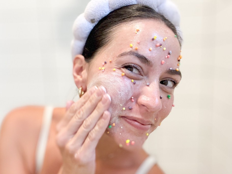 woman scrubbing face with nerds covering it
