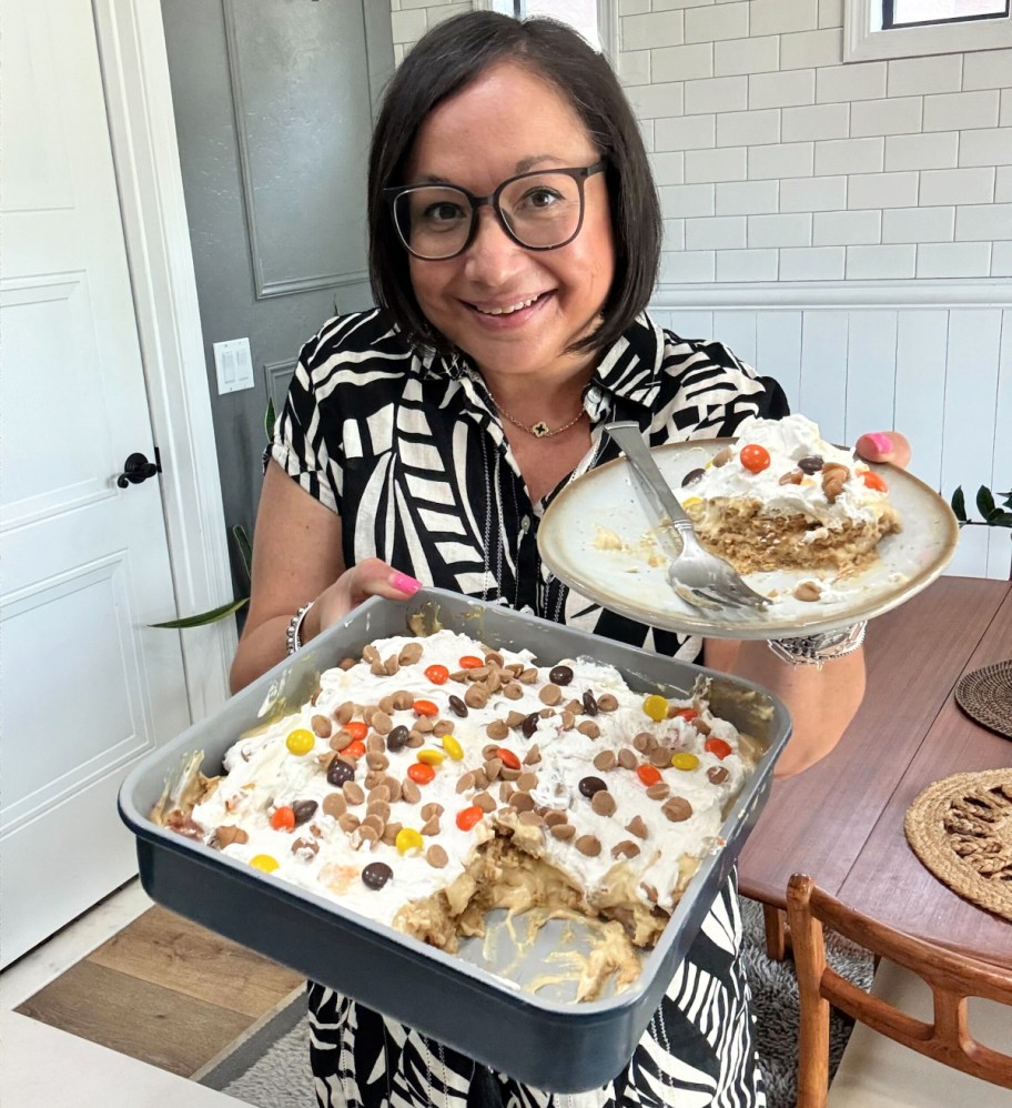 woman holding a plate and pan of nutter butter icebox cake